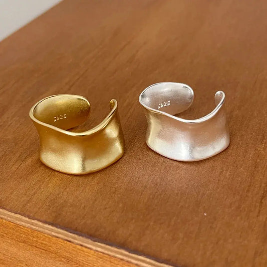 Open Vintage Sterling Silver Ring displayed alongside a gold ring on a wooden surface.