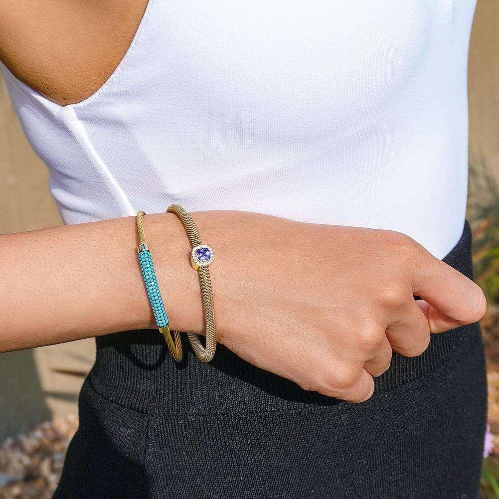 Woman wearing vintage stainless steel jewelry set with gold-tone bracelets one featuring blue stones