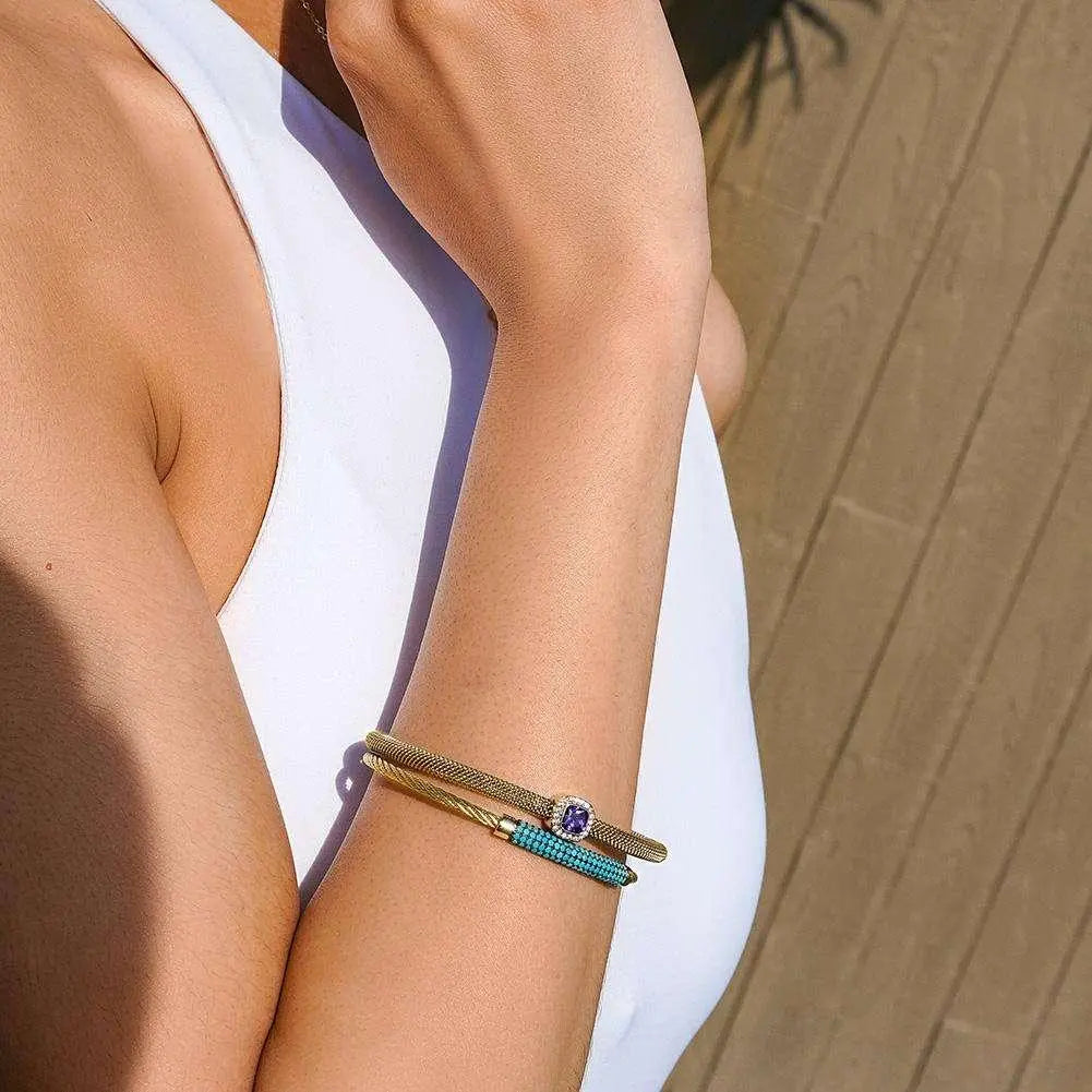 Vintage stainless steel jewelry set featuring gold and turquoise bracelets on a woman’s arm
